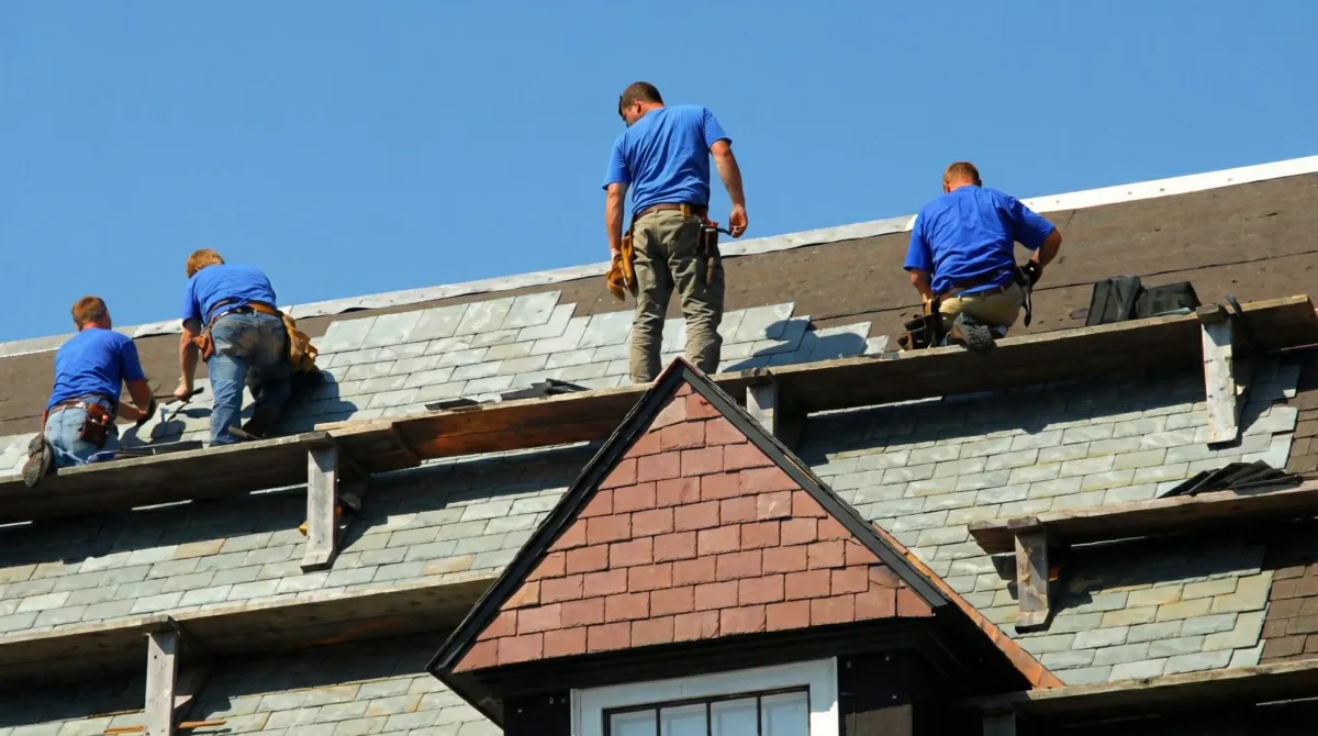 Roof replacement in progress with a team of professional contractors installing new shingles on a residential home in Jackson, MS