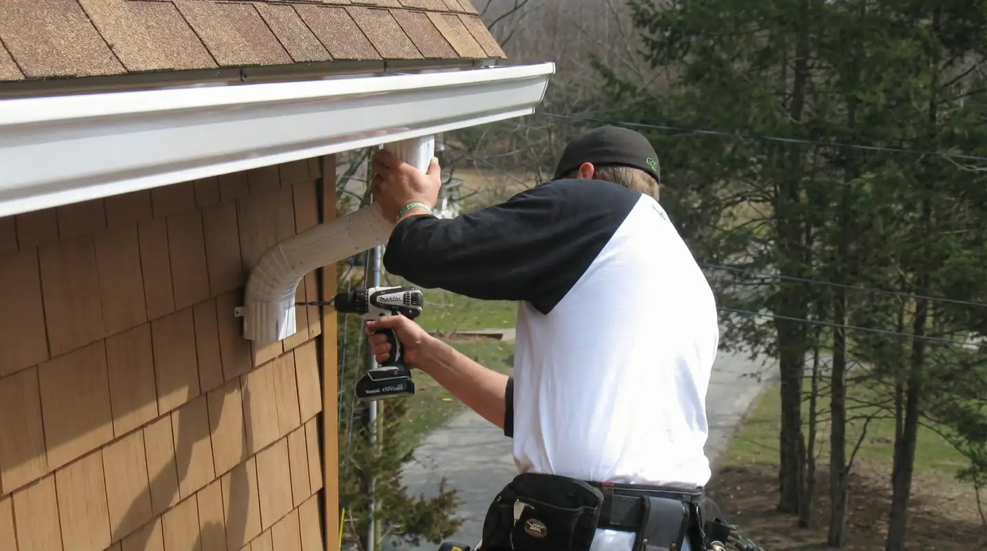 Professional contractor installing tan vinyl siding panels on a residential home exterior in Jackson, MS